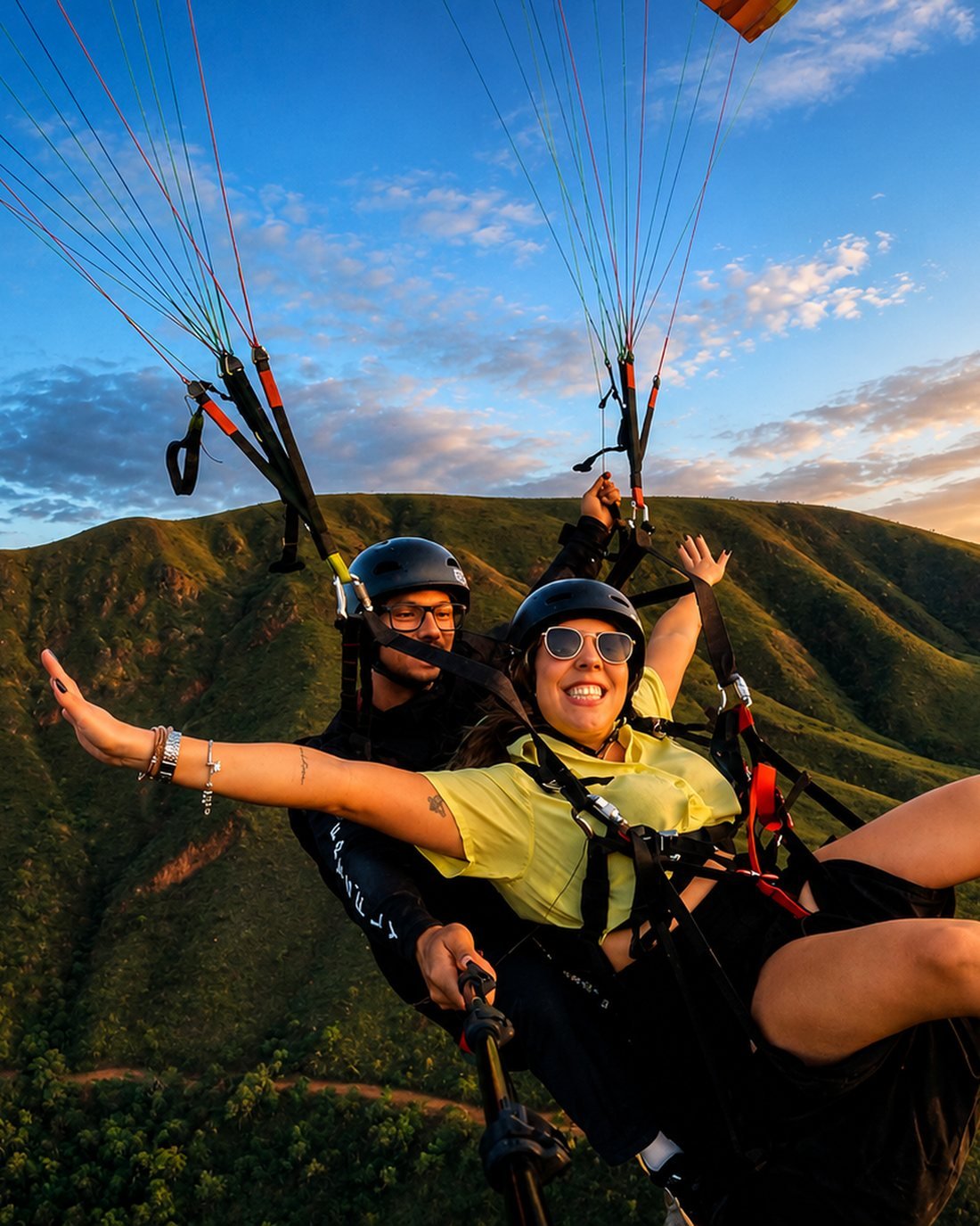 Voo duplo de parapente ao entardecer sobre as montanhas da Serra da Moeda, em Minas Gerais